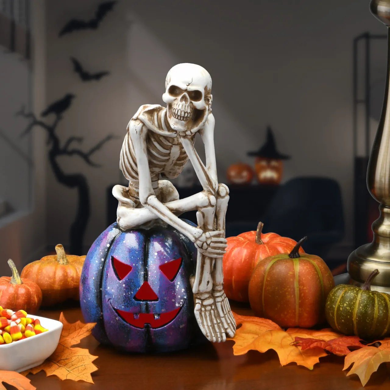 New National Tree Company 11 in. Halloween Skeleton Resting on a Purple Galaxy Jack O Lantern